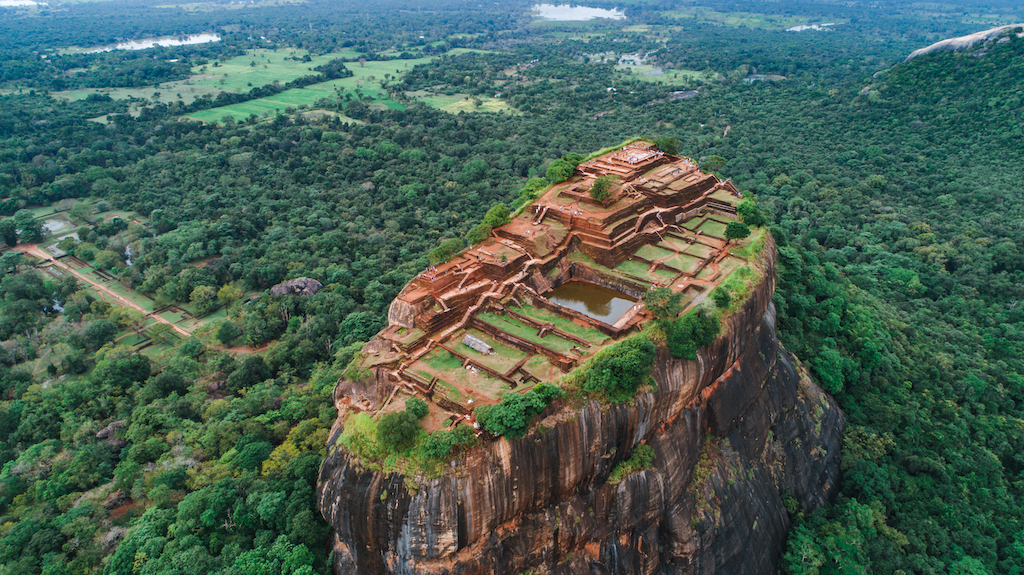 Ancient Sigiriya rock fortress at golden hour surrounded by lush jungle